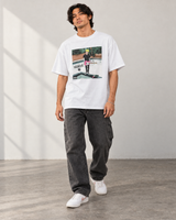 Model wearing the white Believe It Album Cover T-Shirt with charcoal carpenter jeans and white sneakers.