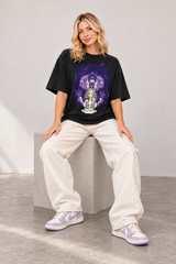 Model wearing the Protect Erii vintage black-gray T-shirt with ecru trousers and lilac sneakers.